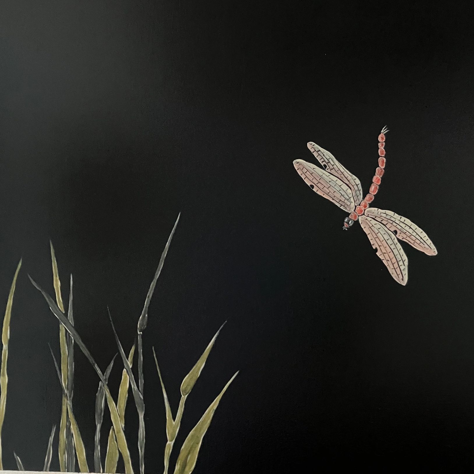 Dragonfly flying towards reeds