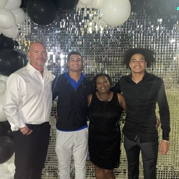 Group photo with four people smiling at an event.