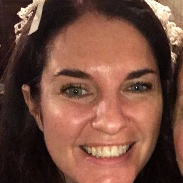 Smiling woman with dark hair and a white headband.