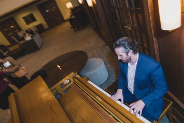 Man playing piano in a cozy room.