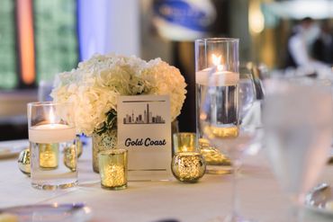 Elegant wedding table centerpiece with white flowers and candles.