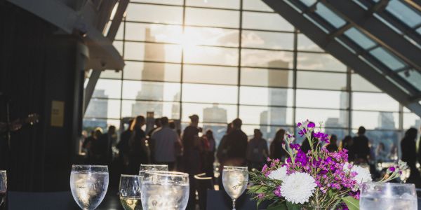 Flowers and glasses at a gathering in a modern venue.