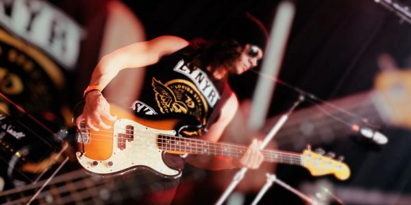 Musician playing electric guitar on stage at concert.