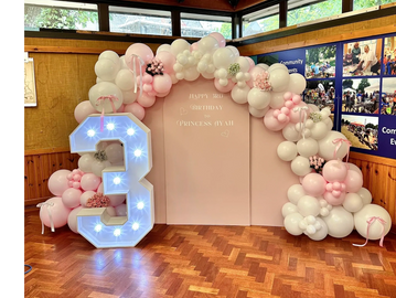Organic balloon display with three pink boards, light up number and custom text with flowers 