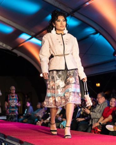 Fashion model walking on runway at night.
