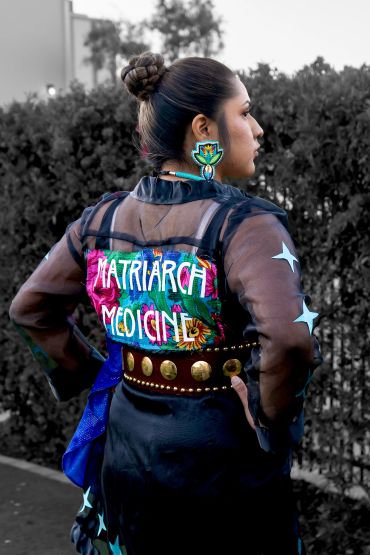 Person wearing a sheer jacket with 'Matriarch Medicine' on the back.