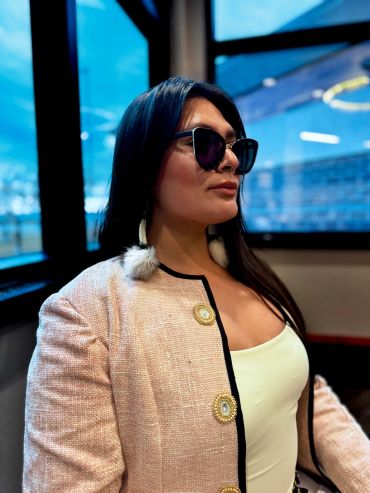 Woman with sunglasses and stylish pink jacket.
