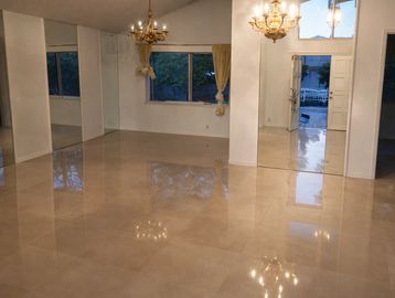 Empty room with glossy tiled floor and chandeliers.