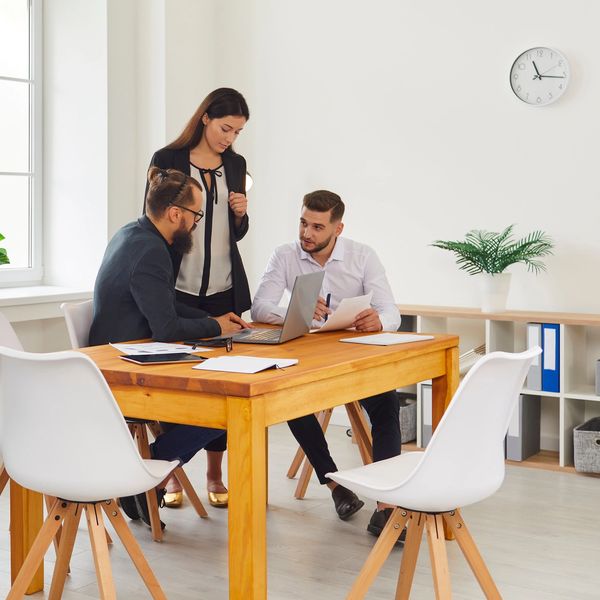 Five professionals engaged in a modern office workspace discussion.