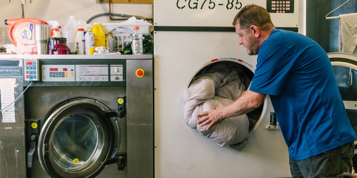 A man putting clothes in washing machine