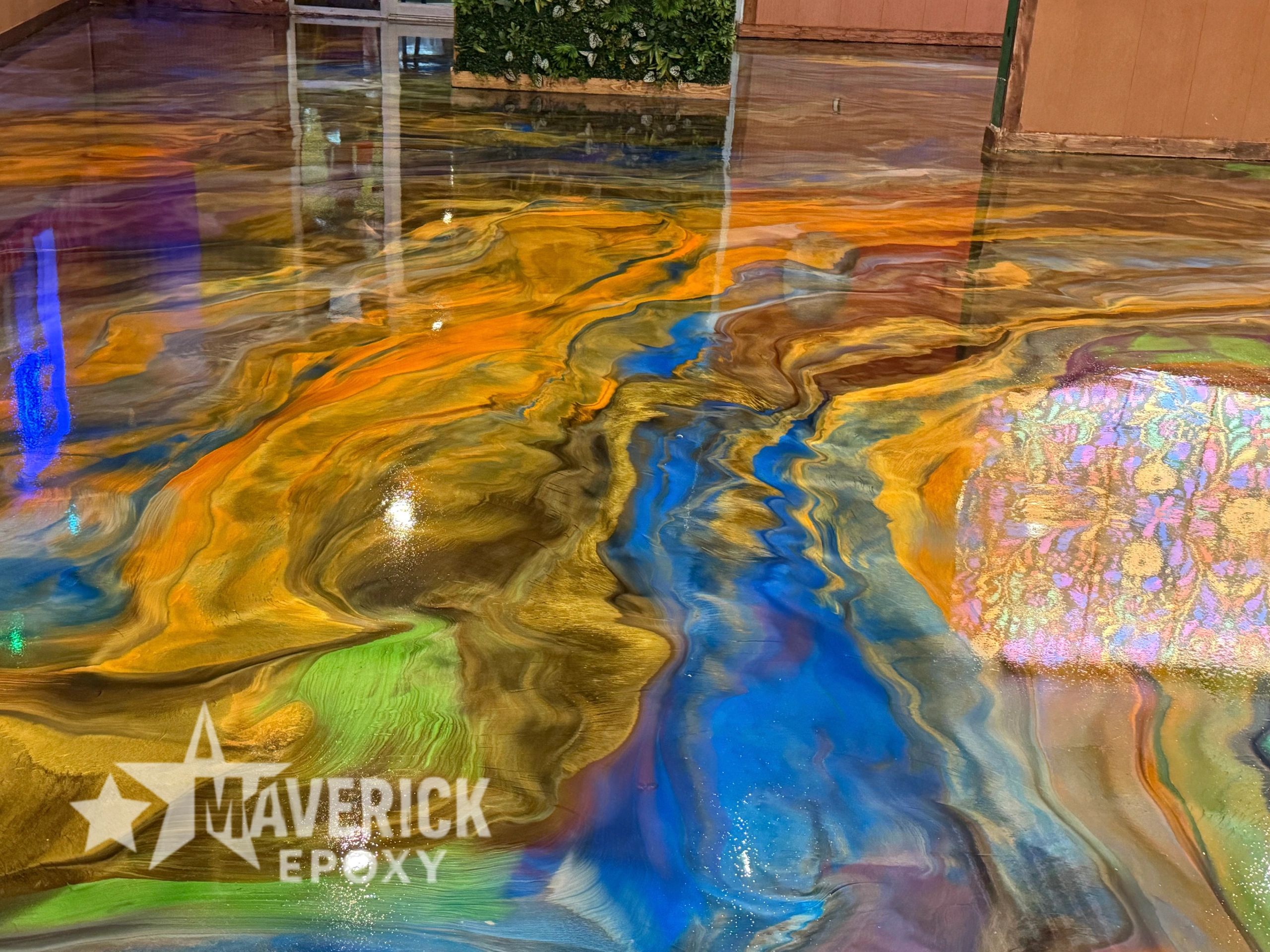Vibrant epoxy floor with swirling colors of blue, orange, green, and purple.