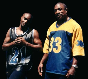 Two men posing in numbered sports jerseys.