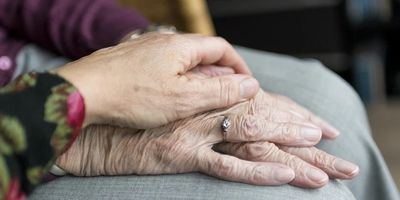 The hands of an elderly woman and her caregiver.