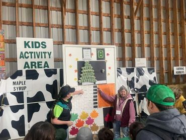 Children participate in a fun activity at a kids' area with a farm-themed backdrop.