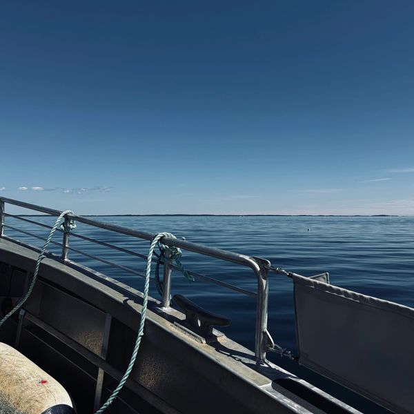 Calm sea view from a boat under a clear blue sky.