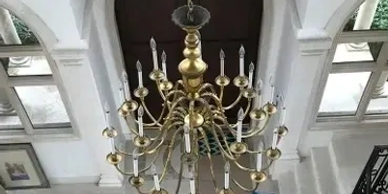 Elegant brass chandelier hanging from a high ceiling.