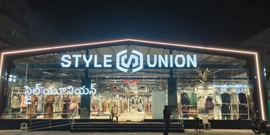 Illuminated Style Union clothing store at night with a glass facade.