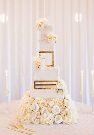 Beautiful two toned fondant cake with gold separators and with a silk flower base.