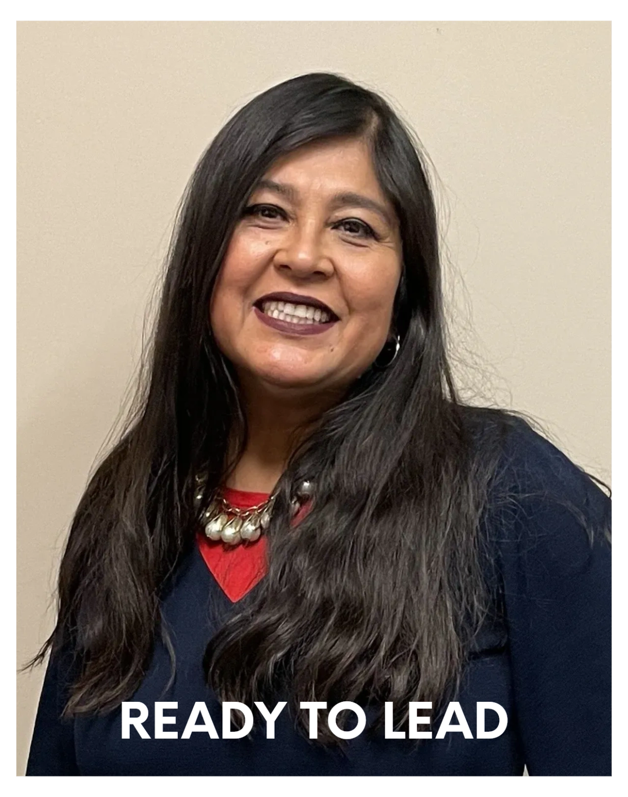 Smiling woman with long hair and necklace.