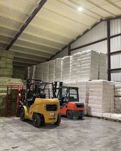 forklift equipment with hay and bedding in background
