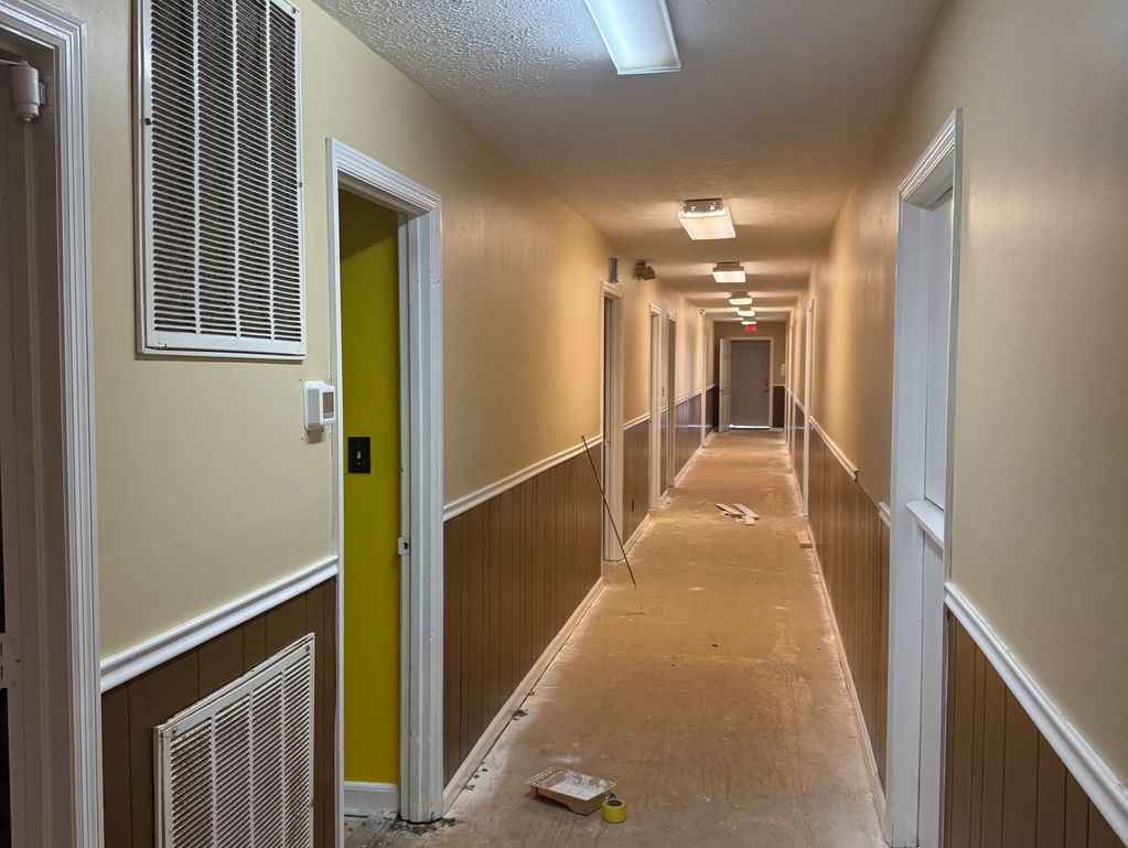 Central hallway connecting multiple rooms within the facility during renovation.