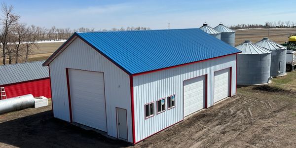 A large metal agricultural building with a blue roof.
