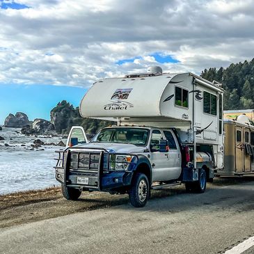 Truck Camper parked next to the ocean.
