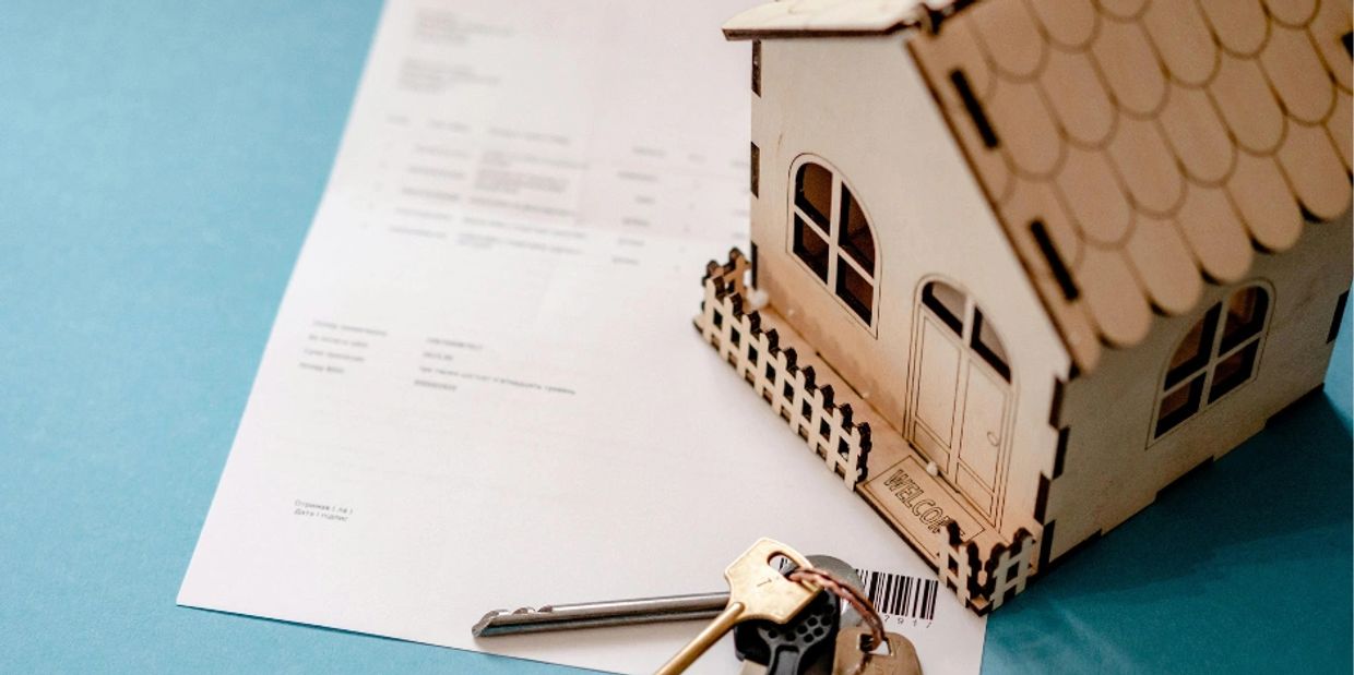 House model on tabletop with paper and keys