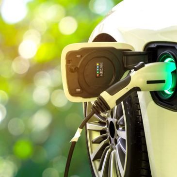Electric car charging with green nature background.