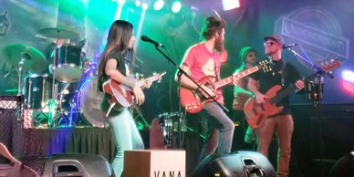 Band performing live on stage with guitars.