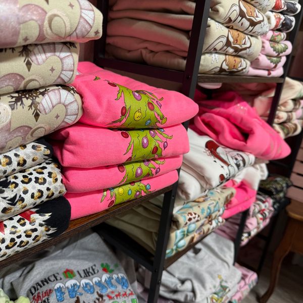 Stacked colorful folded clothes on shelves.