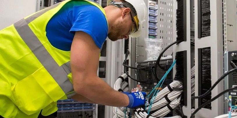 Technician performing on-site installation in a commercial technology infrastructure environment.