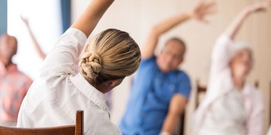 Group seated and stretching arms during a fitness class.