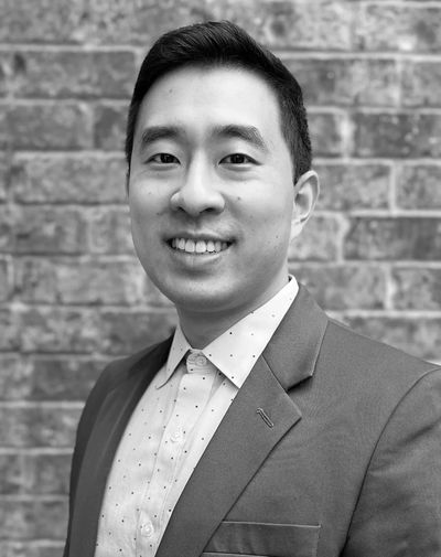 Professional headshot of a smiling man in a suit jacket.