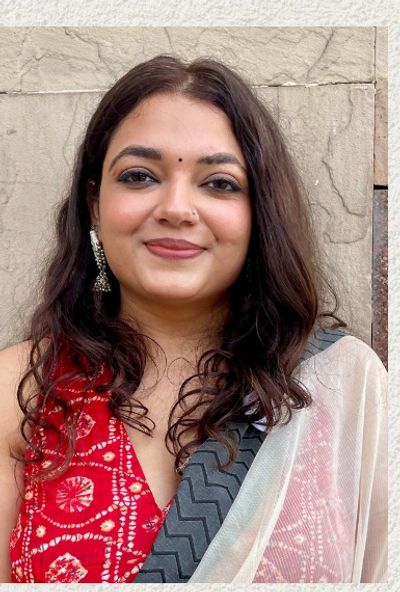 Woman with long hair wearing traditional Indian attire and jewelry.