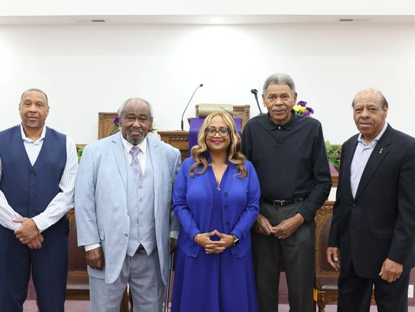 Five people posing together inside a church setting.