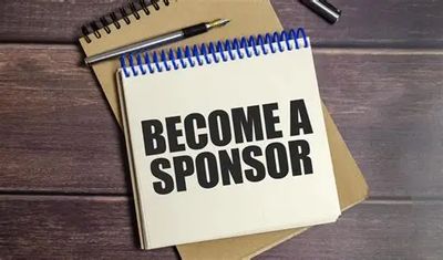 Notepad with the text 'BECOME A SPONSOR' on a wooden table.