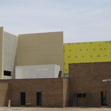 Building under construction with exposed brick and insulation panels.