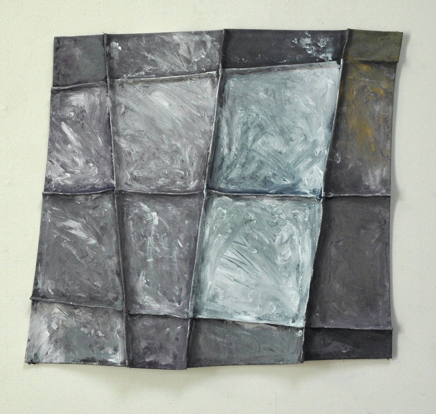 Abstract metal wall art with a grid of textured squares in muted gray tones.