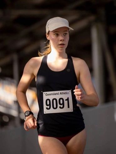 Female athlete running with race number 9091.