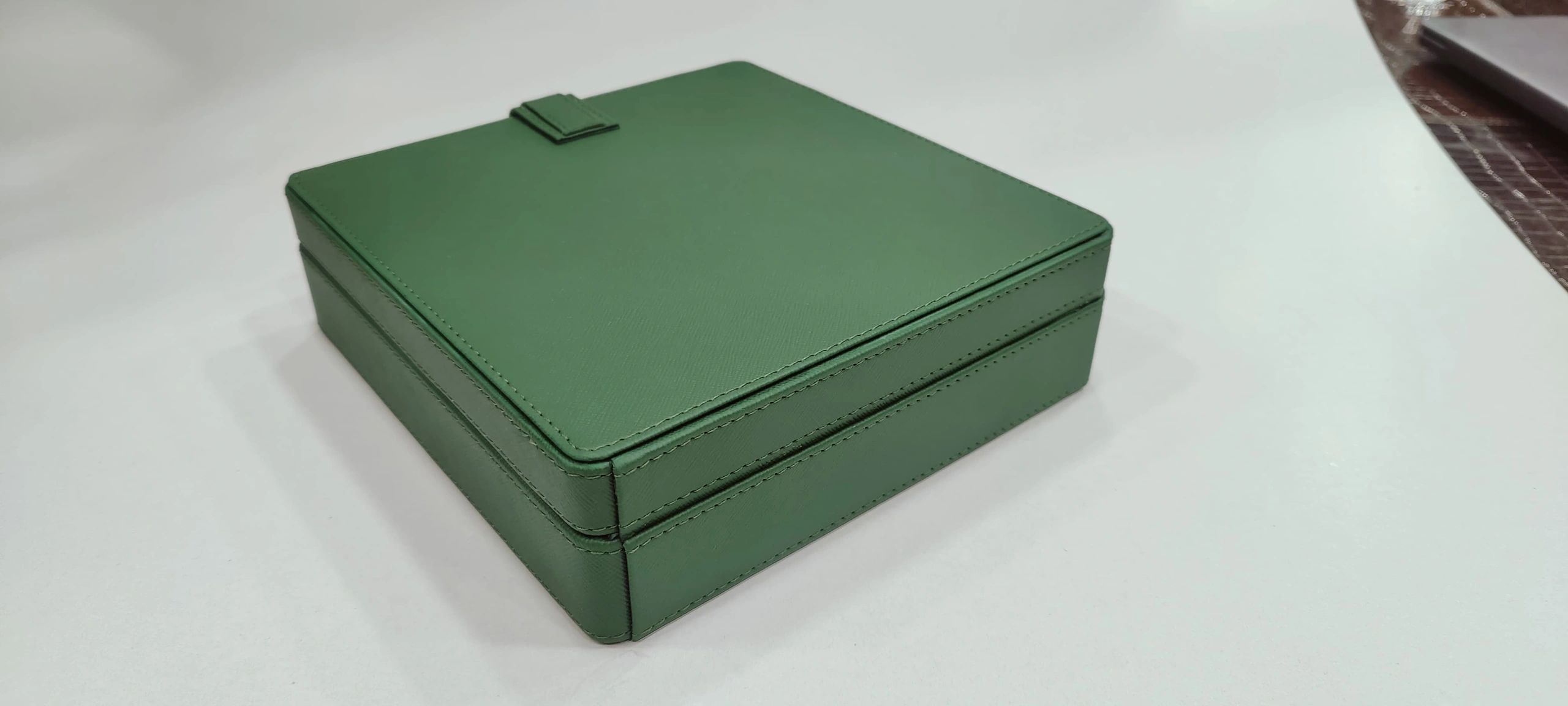 Closed green leather box on a white surface.