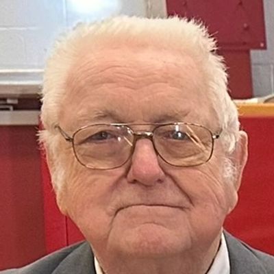 Portrait of an elderly man with glasses and white hair.