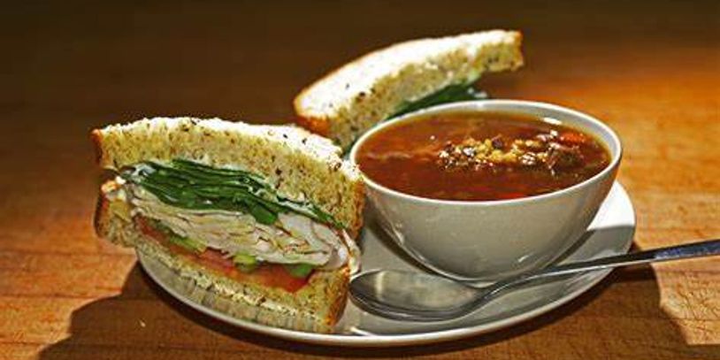 Sandwich with tomato soup on a plate.