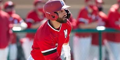 Baseball player in red uniform watching the ball.