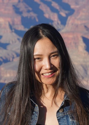 Smiling woman with long dark hair in front of a canyon.