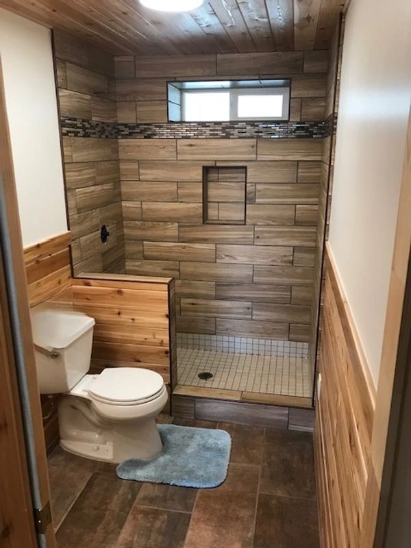 Rustic bathroom with wood accents and a glass shower enclosure.