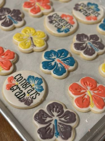 Hawaiian-themed sugar cookies decorated with vibrant hibiscus flowers for graduation.