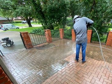 Pressure washing the brick driveway of a home in League city, Texas