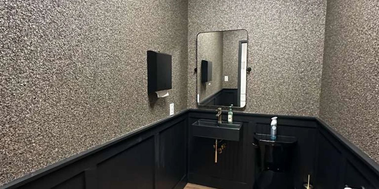 Modern black and gray bathroom with textured walls.