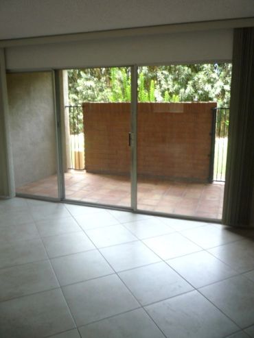 Empty room with glass sliding door and tiled floor.